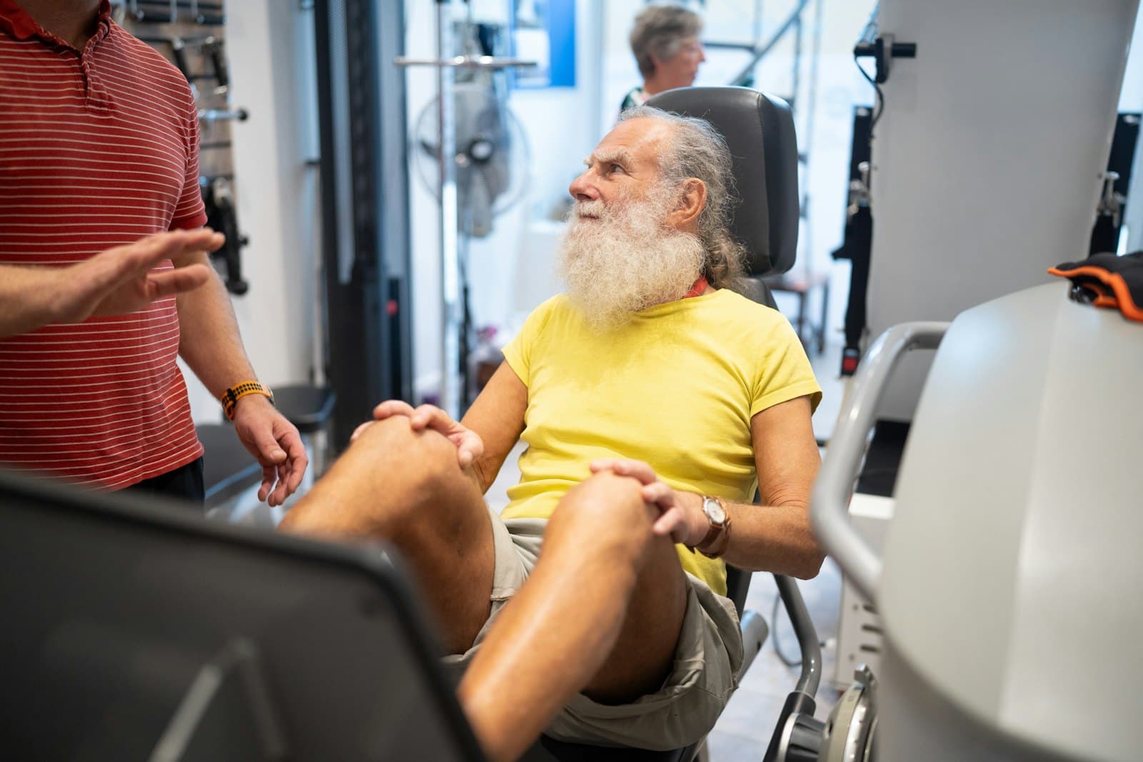 An older man doing a leg exercise with a physiotherapist